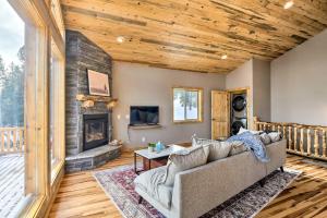 a living room with a couch and a fireplace at Mountainside Fairplay Cabin with Game Room and Sauna! in Fairplay