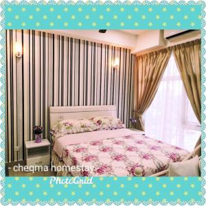 a bedroom with a bed with a pink comforter at Cheqma D'perdana Apartment Kota Bharu in Kota Bharu