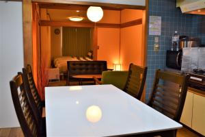 a kitchen and dining room with a table and chairs at Hidamari in Takayama