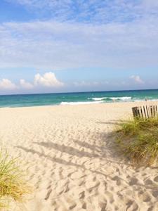 a sandy beach with a trash can on it at Beach Aqualina Apartments in Fort Lauderdale
