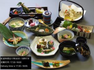 una mesa con muchos platos de comida. en Kuraya Kamigojocho, en Kioto