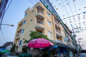 a building with a pink umbrella in front of it at Chomsin Hua Hin ชมสินธุ์ หัวหิน in Hua Hin