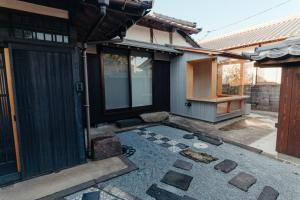 a house with a courtyard with rocks on the ground at 古民家1棟貸し 今魚店の家 in Hagi
