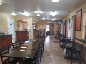 une salle à manger avec des tables et des chaises et un sapin de Noël dans l'établissement Travelodge by Wyndham Kanab, à Kanab