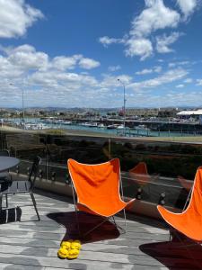 two orange chairs sitting on a roof with yellow shoes at Napier Apartment Ahuriri in Napier +7 photos