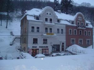 a large building with snow on top of it at Apartmany Ingeborg in Jáchymov
