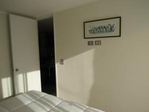 - une chambre avec un lit et une photo sur le mur dans l'établissement Birdhouse Apartment, à Santiago