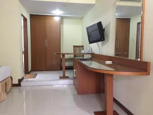 a room with a desk and a tv in a room at Mandalawangi Hotel in Tasikmalaya