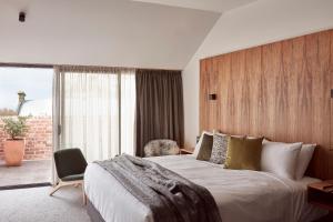 a bedroom with a bed, chair and a tv at Moss Hotel in Hobart