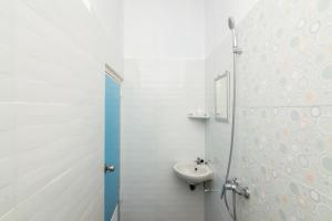 a white bathroom with a sink and a mirror at RedDoorz Syariah near Tanjung Pinang City Center in Tanjung Pinang 