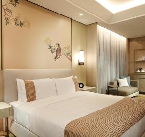 台北市にあるグランド メイフー タイペイのベッドと椅子付きのホテルルーム