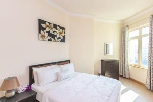 a white bedroom with a bed and a window at Luxury 2 Bed Room Apartment Palm Jumeirah Dubai in Dubai