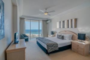 a bedroom with a bed and a desk with a television at Carmel by the Sea in Gold Coast +84 photos