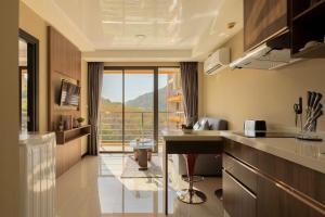 a kitchen with a large window with a view at NaiHarn Sea Condo by Holy Cow, 1-BR, mountain view in Nai Harn Beach