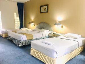 a room with three beds in a hotel room at New Grand Park Hotel in Surabaya +49 photos