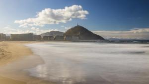 a view of a beach with a hill in the background at BetiJai - Basque Stay in San Sebastián