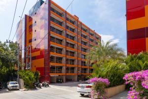 an orange building with a colorful facade on a street at NaiHarn Sea Condo by Holy Cow, 1-BR, mountain view in Nai Harn Beach