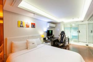 1 dormitorio con cama, escritorio y ordenador en i hotel - Taoyuan en Taoyuan