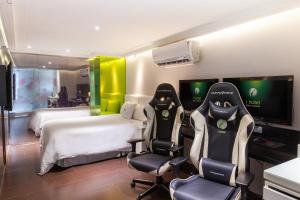 a hotel room with two beds and two chairs at i hotel - Taoyuan in Taoyuan