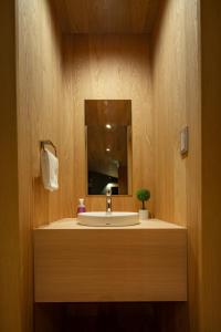 y baño con lavabo y espejo. en Kairos by the Mountain by The Hakuba Collection en Hakuba