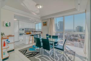 a kitchen and dining room with a table and chairs at Carmel by the Sea in Gold Coast