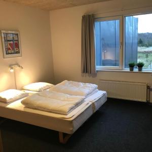 a bedroom with two beds and a window at Sæby Spektrum & Hostel in Sæby