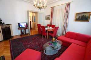 ウィーンにあるMozart Apartments - Rögergasseのリビングルーム(赤いソファ、テーブル付)