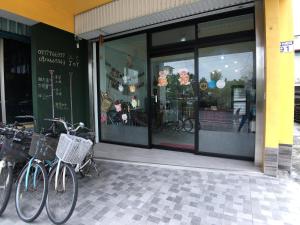 Duas bicicletas estacionadas à porta de uma loja. em JOY Homestay em Shoufeng