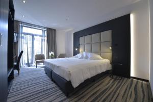 a bedroom with a large bed with a large headboard at Hotel Monarc in Ostend