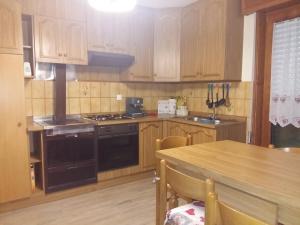 eine Küche mit Holzschränken und einem Holztisch in der Unterkunft La casa alta in Corteno Golgi