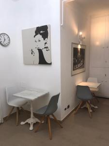 uma mesa e cadeiras num quarto com um relógio em Art Atelier Vaticano em Roma
