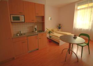 eine kleine Küche mit einem Tisch und einem Bett in der Unterkunft Wohnen in Innsbruck in Innsbruck
