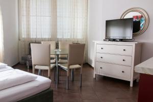 1 dormitorio con mesa, sillas y TV en Wohnen in Innsbruck, en Innsbruck