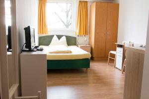 1 dormitorio con 1 cama y escritorio con TV en Wohnen in Innsbruck en Innsbruck