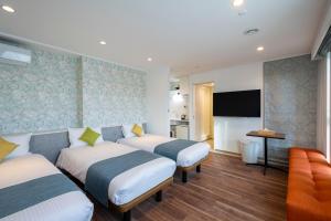 ein Hotelzimmer mit 2 Betten und einem Flachbild-TV in der Unterkunft Hotel SAILS Asakusa in Tokio