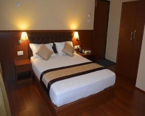 Ein Bett oder Betten in einem Zimmer der Unterkunft Juniper Residency Hotel