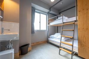 Zimmer mit einem Etagenbett, einem Waschbecken und einem Etagenbett in der Unterkunft Wise Owl Hostels Kyoto in Kyoto