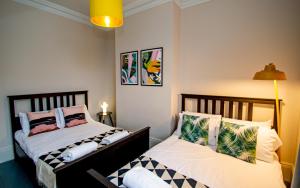 ein Schlafzimmer mit 2 Betten und einer Lampe in der Unterkunft Number Twenty Four Townhouse - Sleeps 22 in Brighton & Hove