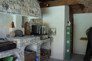 a living room with a stone fireplace with a microwave at Studio au coeur de la petite camargue in Beauvoisin