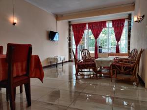 a dining room with a table and chairs and a window at Pereybere Beach Apartments in Pereybere