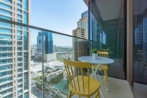 a table and chairs on a balcony with a view of a city at GuestReady - Cactus Bloom Marina Gate in Dubai