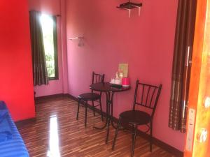 a room with three chairs and a table with pink walls at Banphu Resort - บ้านปู รีสอร์ท in Rayong