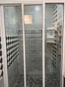 La salle de bains est pourvue d'une douche avec une porte en verre. dans l'établissement ร่มปาล์มรีสอร์ท สระบุรี Rompalm Saraburi, à Sara Buri