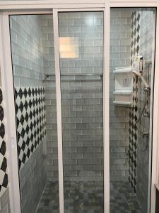 a shower with a glass door in a bathroom at ร่มปาล์มรีสอร์ท สระบุรี Rompalm Saraburi in Sara Buri