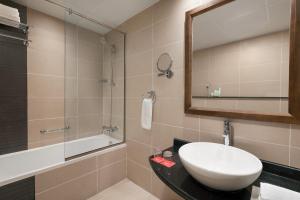 a bathroom with a sink, toilet and bathtub at Ramada by Wyndham Dubai Deira in Dubai
