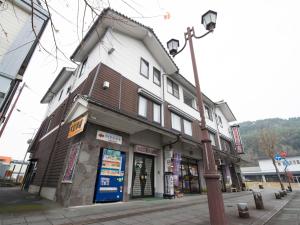 a building on the corner of a street with a street light at Station Business Hotel Tenshukaku in Hitoyoshi