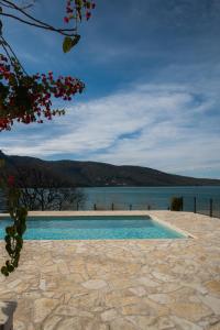 a swimming pool next to a body of water at Velanidia Apartments in Plataria