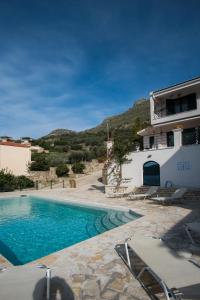 a villa with a swimming pool and a house at Velanidia Apartments in Plataria