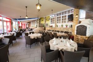a restaurant with tables and chairs in a room at Major Panzió és Étterem in Hajdúszoboszló