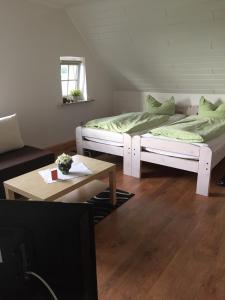 ein Wohnzimmer mit 2 Betten und einem Couchtisch in der Unterkunft Ferienhof Pankalla in Neubruchhausen